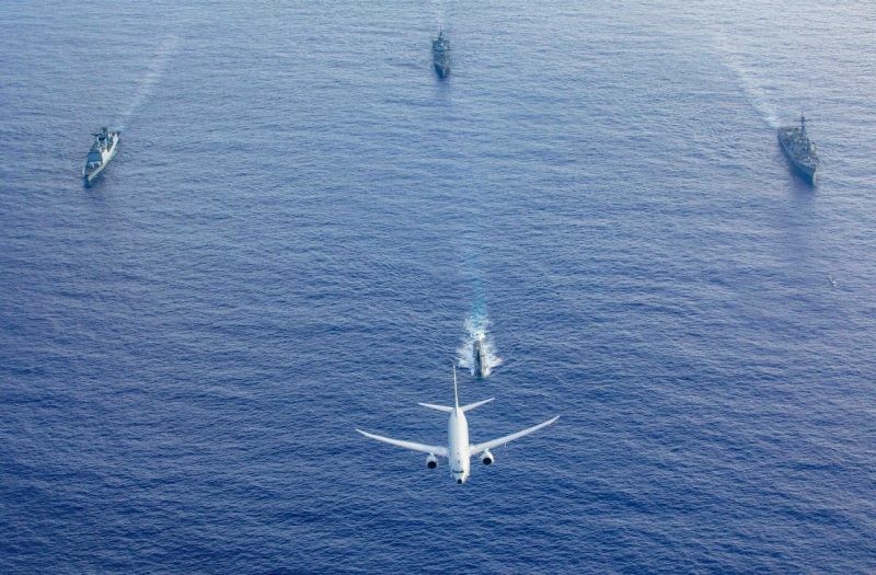 A U.S. Navy P-8 Poseidon flies above a formation of surface ships and submarines from the United States, Japan, and the Republic of Korea in the Philippine Sea during Pacific Vanguard 23, July 4, 2023. 